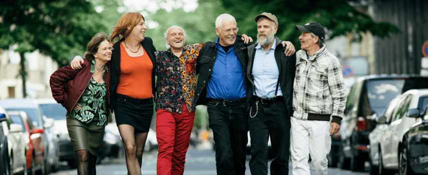 Group of LGBTQIA+ friends laughing and walking together