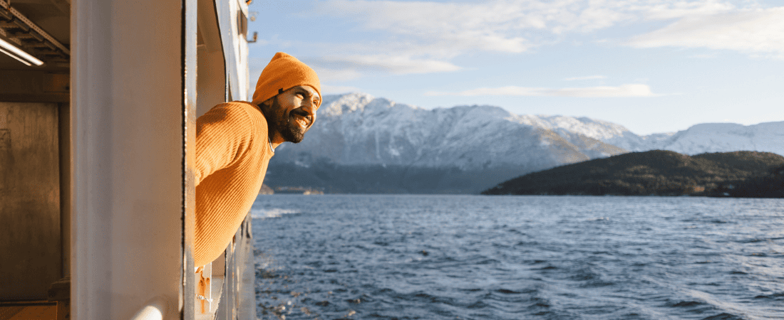 Traveller enjoying the view of mountains from his cruise ship balcony
